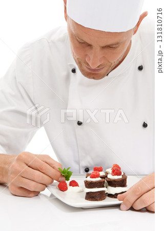 Cook, dessert and mint on sweet chocolate or berries on food by culinary chef with recipe on a plate in white studio background. Cooking, presentation and man or person making mini cakes as cuisine Cook, dessert and mint on sweet chocolate or berries on food by culinary chef with recipe on a plate in white studio background. Cooking, presentation and man or person making mini cakes as cuisine 131810716