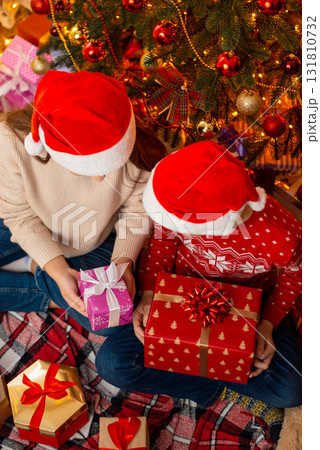 Two children girl and boy at Christmas morning opening presents. Christmas celebration concept, happy children Two children girl and boy at Christmas morning opening presents. Christmas celebration concept, happy children 131810732