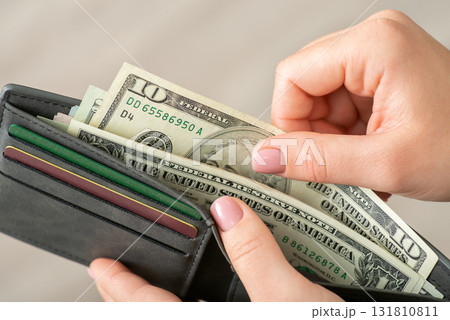 Dollar money in grey wallet, female hands holding them. Ten dollar banknotes and credit cards, close up 131810811