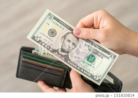 Close up shot of five dollar banknote in hands on a woman. American money, finances, payments concept 131810814