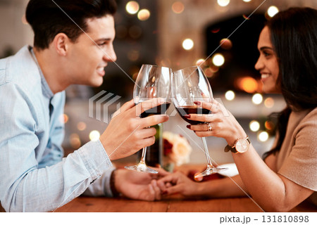 Couple holding hands at table, love and cheers with wine on valentines day date at home with smile and bokeh. Date night, man and woman in living room, valentine celebration and happy relationship. 131810898