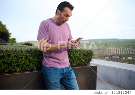 Casual Man Standing Outdoors Near Stairs and Greenery for Everyday Fashion and Lifestyle Photo Casual Man Standing Outdoors Near Stairs and Greenery for Everyday Fashion and Lifestyle Photo 131811044