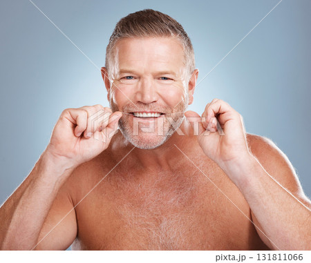 Floss, portrait and man with oral hygiene to clean mouth, wellness and guy against blue studio background. Male, gentleman and string for fresh breath, dental health and morning routine or grooming Floss, portrait and man with oral hygiene to clean mouth, wellness and guy against blue studio background. Male, gentleman and string for fresh breath, dental health and morning routine or grooming 131811066