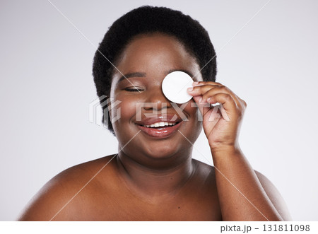 Beauty, skincare and plus size with a model black woman in studio on a gray background for exfoliation. Face, skin and cotton swab with an attractive young female posing to promote natural health 131811098