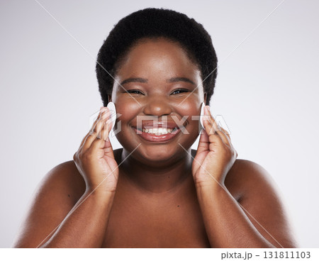 Black woman, skincare and studio portrait with cotton pad for cleaning, skin glow or wellness with smile. African model, cosmetics and makeup for dermatology, aesthetic or facial health for self care 131811103