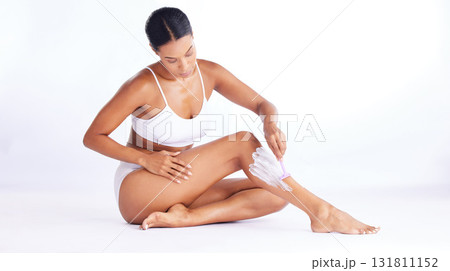 Skincare, legs and shaving, woman in studio sitting with hand on leg and razor for hair removal product placement. Smooth shave, skin and beauty, body care mockup, girl isolated on white background. Skincare, legs and shaving, woman in studio sitting with hand on leg and razor for hair removal product placement. Smooth shave, skin and beauty, body care mockup, girl isolated on white background. 131811152