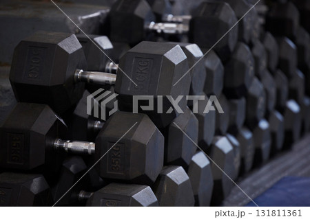 Fitness, workout and dumbbells in empty gym for exercise, bodybuilding development and sports training club. Background zoom of heavy steel weights, equipment and iron for lifting in wellness studio Fitness, workout and dumbbells in empty gym for exercise, bodybuilding development and sports training club. Background zoom of heavy steel weights, equipment and iron for lifting in wellness studio 131811361