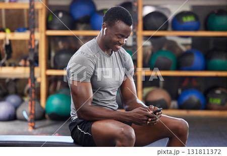 Phone, fitness and black man in gym training, workout or exercise social media or internet search for health tips. Bodybuilder, sports person listening to music or typing on smartphone chat or mobile Phone, fitness and black man in gym training, workout or exercise social media or internet search for health tips. Bodybuilder, sports person listening to music or typing on smartphone chat or mobile 131811372