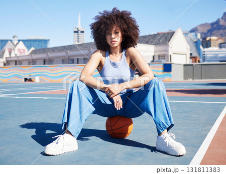 Fashion, city and portrait of black woman with basketball court with trendy, urban style and edgy clothes. Sports, fitness park and girl pose outdoors with ball with confidence and attitude 131811383
