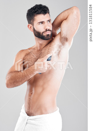 Deodorant, spray and man in studio grooming for hygiene, fresh scent or sweating smell. Male model spraying armpit of body odor, beauty cosmetics and cleaning skincare of bottle product on background 131811584