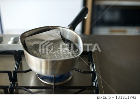 レトルトのカレーを鍋で温めているところ 131811742