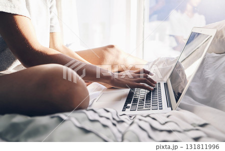 Laptop, hands and typing in bed in bedroom for social, media or internet browsing in the morning. Digital technology, remote worker and woman working on project, writing email or research on computer 131811996