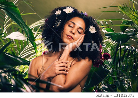 Beauty, flowers and black woman in studio for wellness, skincare and creative advertising in a jungle. Facial, skin and girl model relax in zen, peace and products from nature, forest and aesthetic 131812373