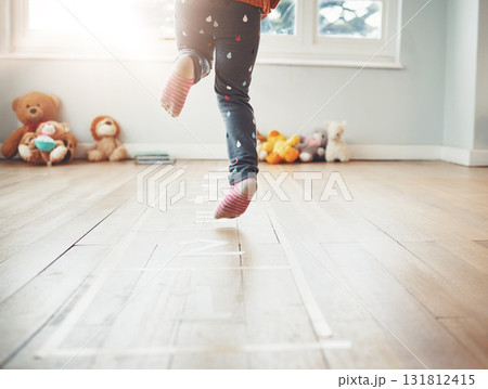 Hopscotch, happy and feet of child play in home having fun, enjoying games and entertainment in room. Childhood, kindergarten and excited girl in bedroom for jumping game, playing and floor activity Hopscotch, happy and feet of child play in home having fun, enjoying games and entertainment in room. Childhood, kindergarten and excited girl in bedroom for jumping game, playing and floor activity 131812415