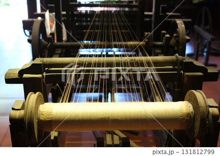 Separate silk worm via spinning wheel, Thai wisdom. process highlights sustainable textile making, natural materials, and the dedication in rural workshops. 131812799