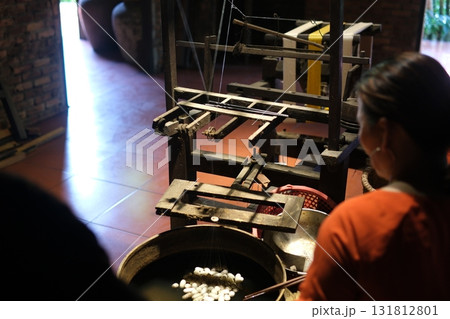 Separate silk worm via spinning wheel, Thai wisdom. process highlights sustainable textile making, natural materials, and the dedication in rural workshops. 131812801