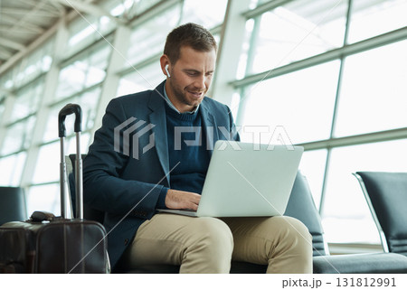 Airport, business man and laptop for music during travel or working in lobby streaming internet. Entrepreneur person with luggage in building for video call while typing email, search or news Airport, business man and laptop for music during travel or working in lobby streaming internet. Entrepreneur person with luggage in building for video call while typing email, search or news 131812991