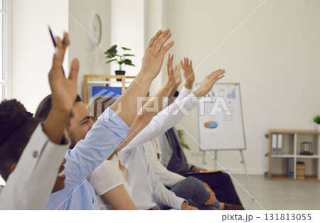 Audience raising their hands to ask questions at a business conference or seminar Audience raising their hands to ask questions at a business conference or seminar 131813055