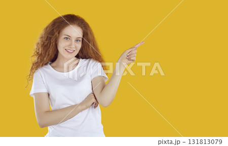 Smiling young woman pointing her finger to side Smiling young woman pointing her finger to side 131813079