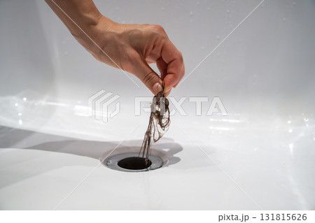 Water drain hole in bath is clogged with hair clump in bathroom at home. Water drain hole in bath is clogged with hair clump in bathroom at home. 131815626