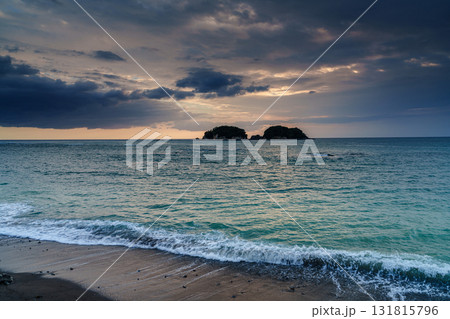 雲間から覗く夕焼けと グラデーションの空と海　砂浜に打ち寄せる白波③ 131815796