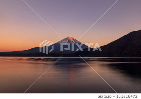 「山梨県」本栖湖越しに夕日に染まった富士山を見る 131816472