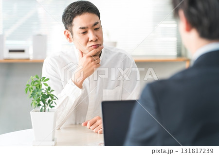 相談窓口で商談中に検討,悩む,考える中年のアジア人男性顧客 相談窓口で商談中に検討,悩む,考える中年のアジア人男性顧客 131817239