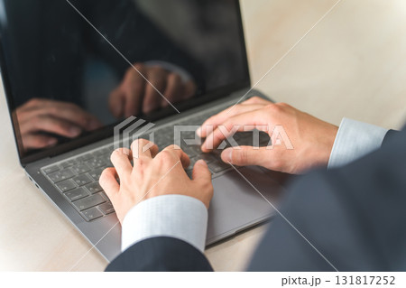 ノートパソコンでタイピングするスーツの男性の手元 ノートパソコンでタイピングするスーツの男性の手元 131817252