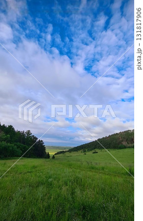 Wide open valley under dramatic cloudy blue sky Wide open valley under dramatic cloudy blue sky 131817906