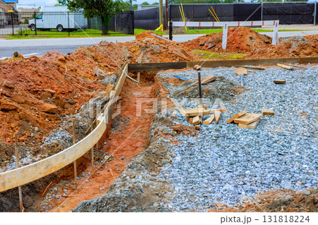 Workers prepare construction site with gravel wooden frameworks for new building foundation 131818224