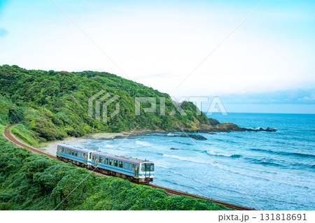 海沿い朝色の中を走るローカル線 131818691