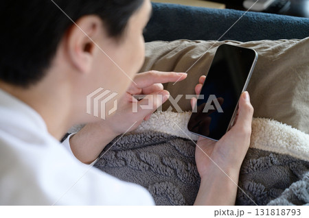 ベッドでスマホを操作する男性 131818793