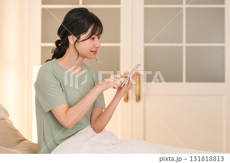 夜ベッドに入りスマホを見る若いアジア人女性 131818813