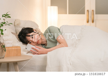 夜ベッドに入りスマホを見る若いアジア人女性 131818817
