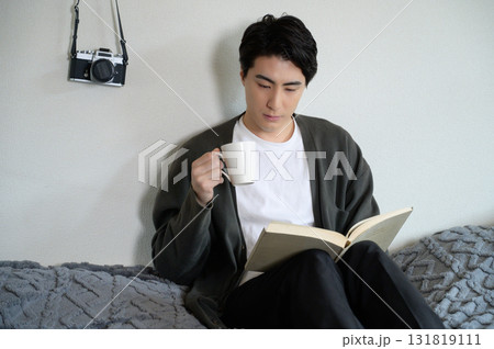 ベッドに座って本を読む男性 ベッドに座って本を読む男性 131819111