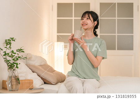 夜の寝室でホットドリンクを飲む若いアジア人女性 夜の寝室でホットドリンクを飲む若いアジア人女性 131819355