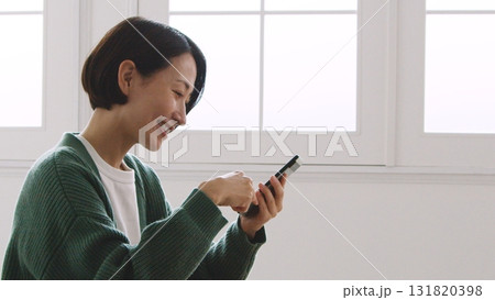 笑顔で携帯の画面をみる40代の女性 笑顔で携帯の画面をみる40代の女性 131820398