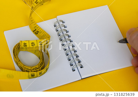 Diet measurement tape with blank notebook. 131825639