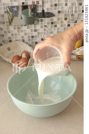Anonymous person prepares dough with milk in bowl. Healthy eating with organic, gluten-free ingredients. Home cooking. 131825861