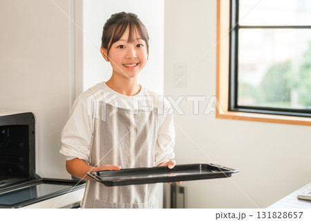 自宅のキッチンでオーブンのトレーを持つ小学生,中学生の女の子（お菓子作り） 131828657