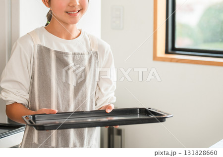 自宅のキッチンでオーブンのトレーを持つ小学生,中学生の女の子(お菓子作り) 自宅のキッチンでオーブンのトレーを持つ小学生,中学生の女の子(お菓子作り) 131828660