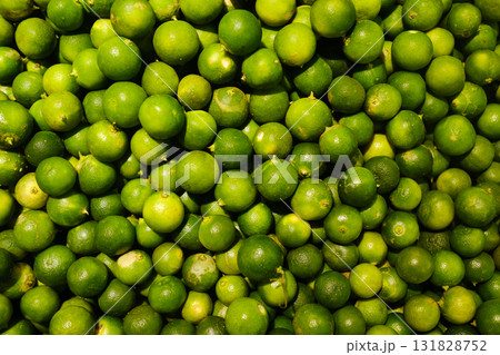 Fresh limes piled together in a vibrant display at a local market during the morning hours of a sunny day Fresh limes piled together in a vibrant display at a local market during the morning hours of a sunny day 131828752