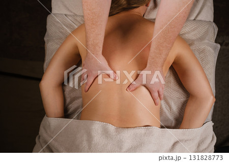 Relaxation therapy session providing stress relief through back massage for wellness at a spa facility during afternoon hours Relaxation therapy session providing stress relief through back massage for wellness at a spa facility during afternoon hours 131828773