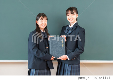 教室の黒板の前で卒業証書を持つ高校生・女子高生（卒業生・卒業式・卒業） 131831151