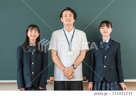 教室の黒板の前にいる男性教師と小学生,中学生,高校生の女子生徒 131831235