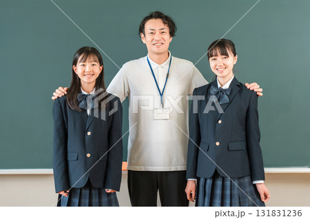 教室の黒板の前にいる男性教師と小学生,中学生,高校生の女子生徒 131831236