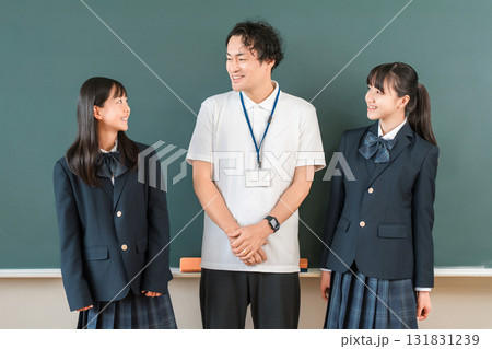 教室の黒板の前にいる男性教師と小学生,中学生,高校生の女子生徒 131831239