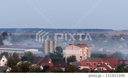 an industrial disaster. A factory building is engulfed in a destructive fire blaze, releasing thick, black smoke that heavily contributes to CO2 and air pollution. CO2 emissions factory disaster 131831300
