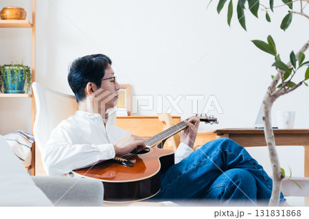 リビングでギターを弾く中年男性 131831868