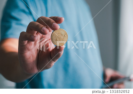Hand holding a coin focus business setting close-up shot indoor environment financial concept 131832052